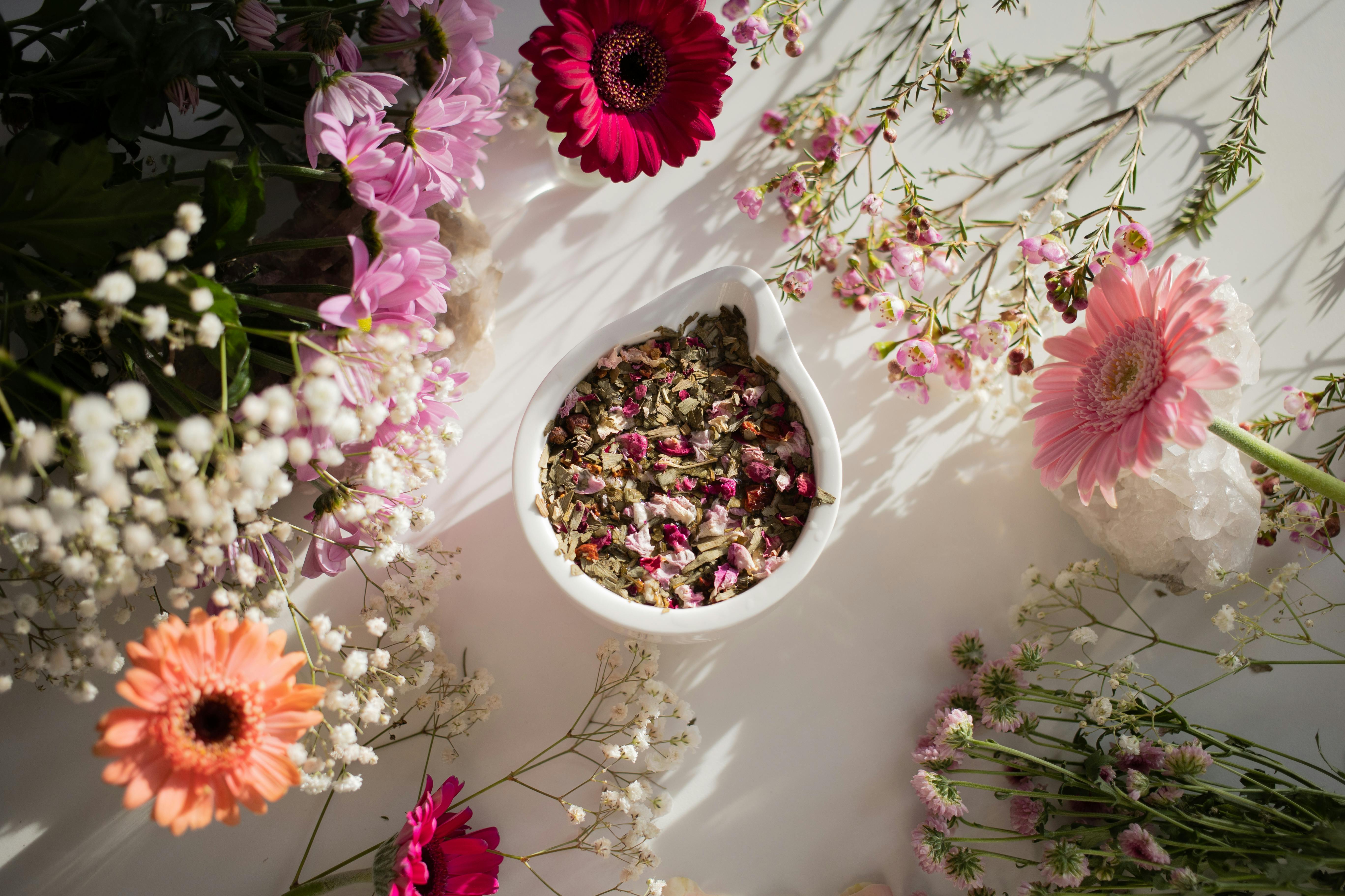 A bowl filled with colorful flowers and fresh herbs